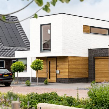 Houten afwerking bij toegang hoofdgebouw en garage.